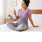 Woman using heating pad for lower back pain relief at home during rest time, comfortable heat therapy solution for everyday pain relief by Metron