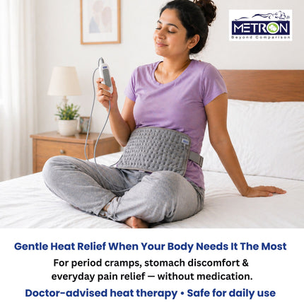 Woman using heating pad for period cramps stomach discomfort and back pain relief with gentle heat therapy at home by Metron